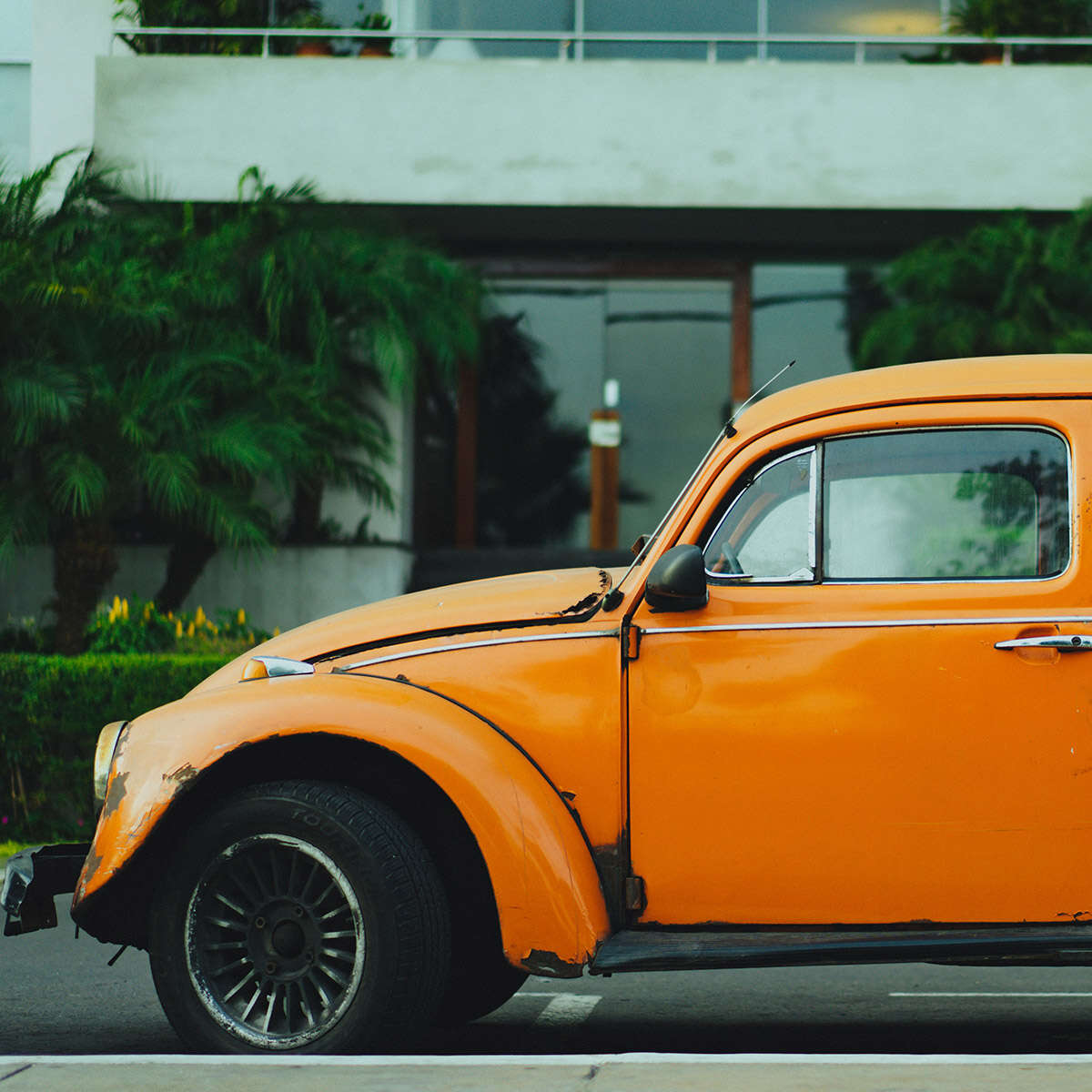Orange classic Volkswagen Beetle parked outdoors.